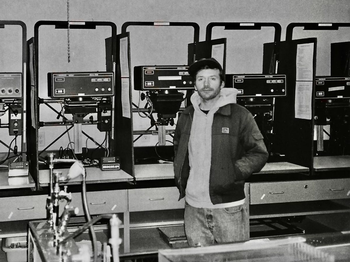 Chris Gould at Solano Community College, standing in front of the darkroom enlargers. 