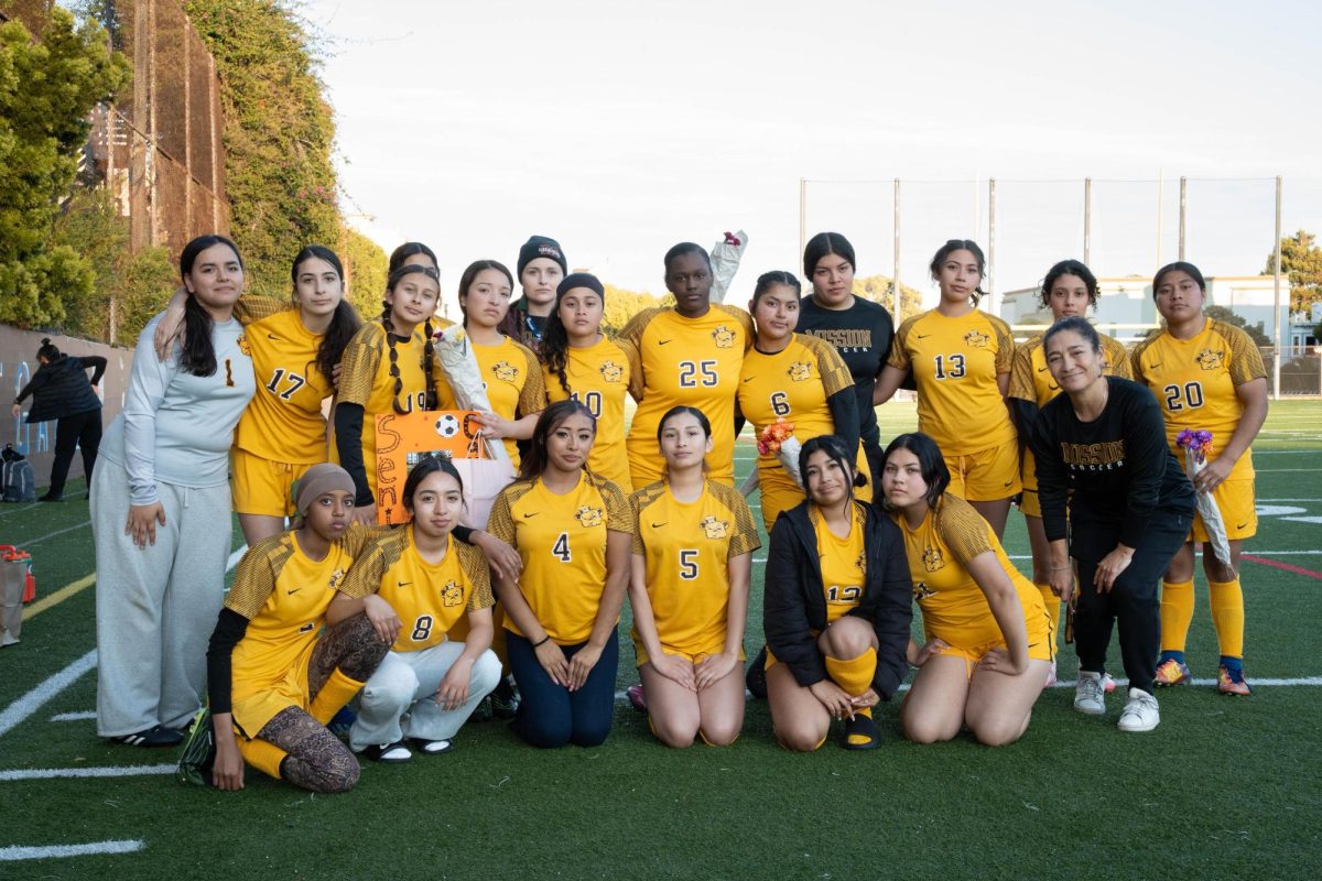 MHS girls' soccer team taking a group photo on the field at Mission High School.
